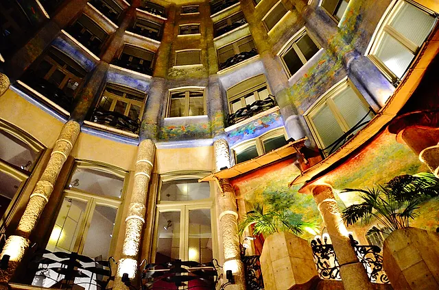 Looking up the inner courtyard of La Pedrera, with its curved walls, painted decoration and rows of windows rising to the sky
