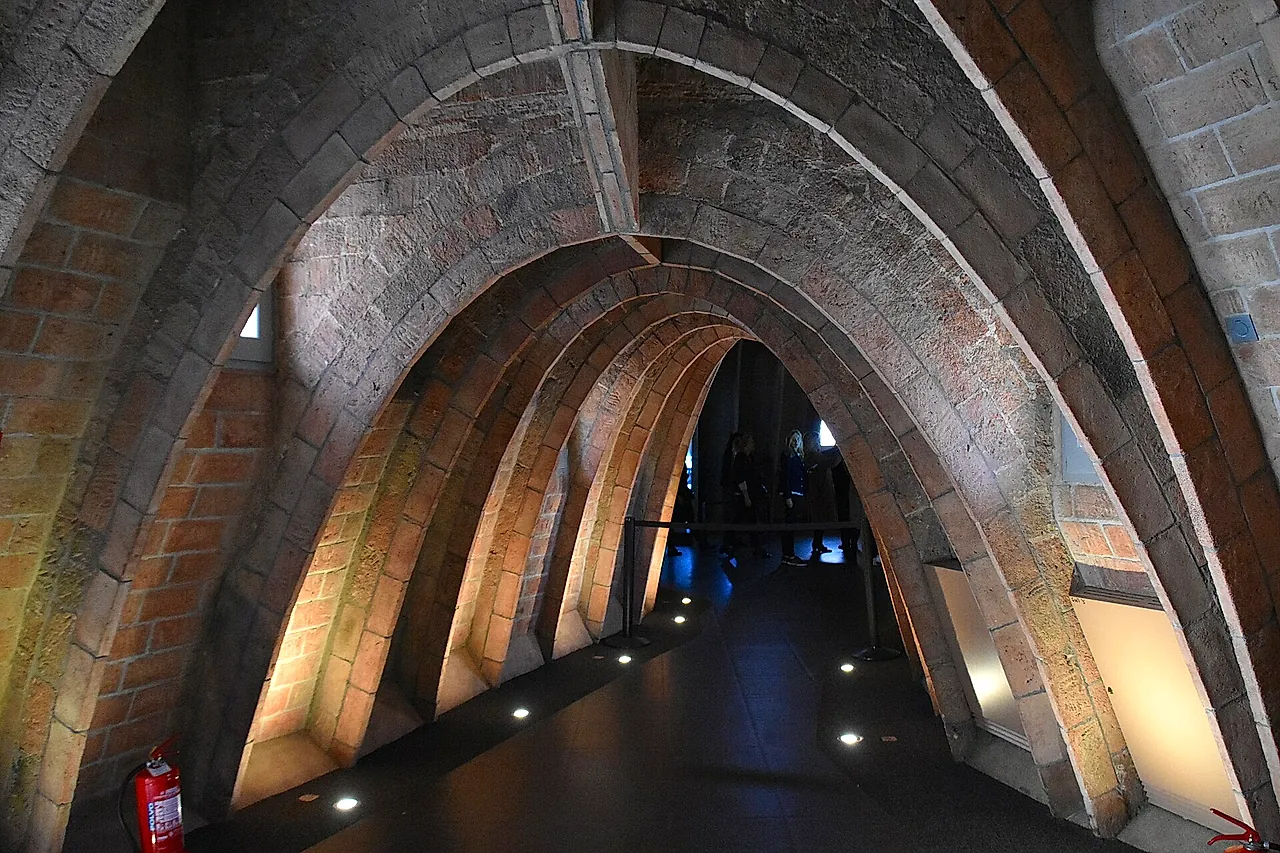 The attic of La Pedrera, a long corridor of brick catenary arches lit from below along the floor
